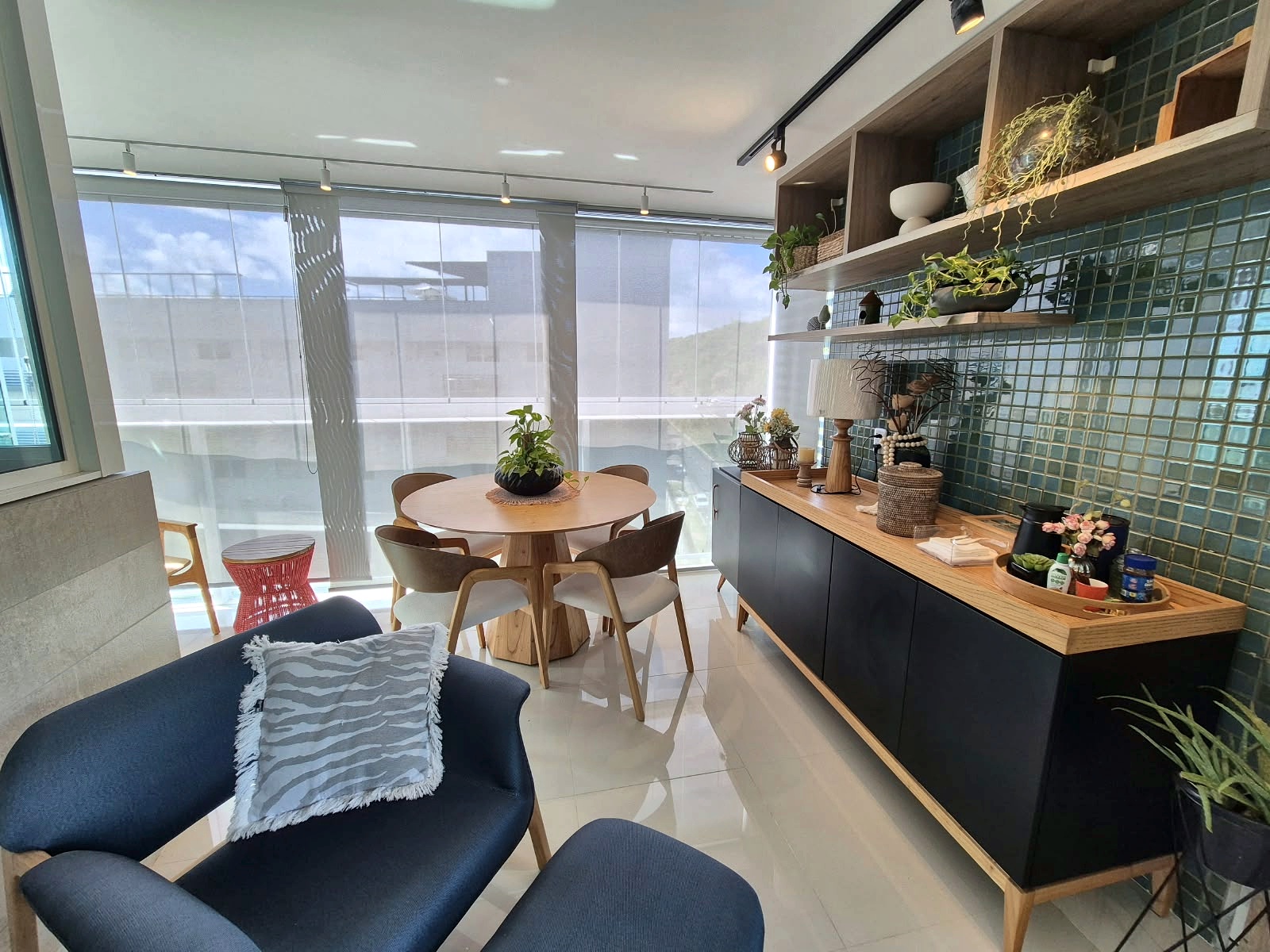 Sala de jantar integrada ao living, com mesa de madeira e poltronas